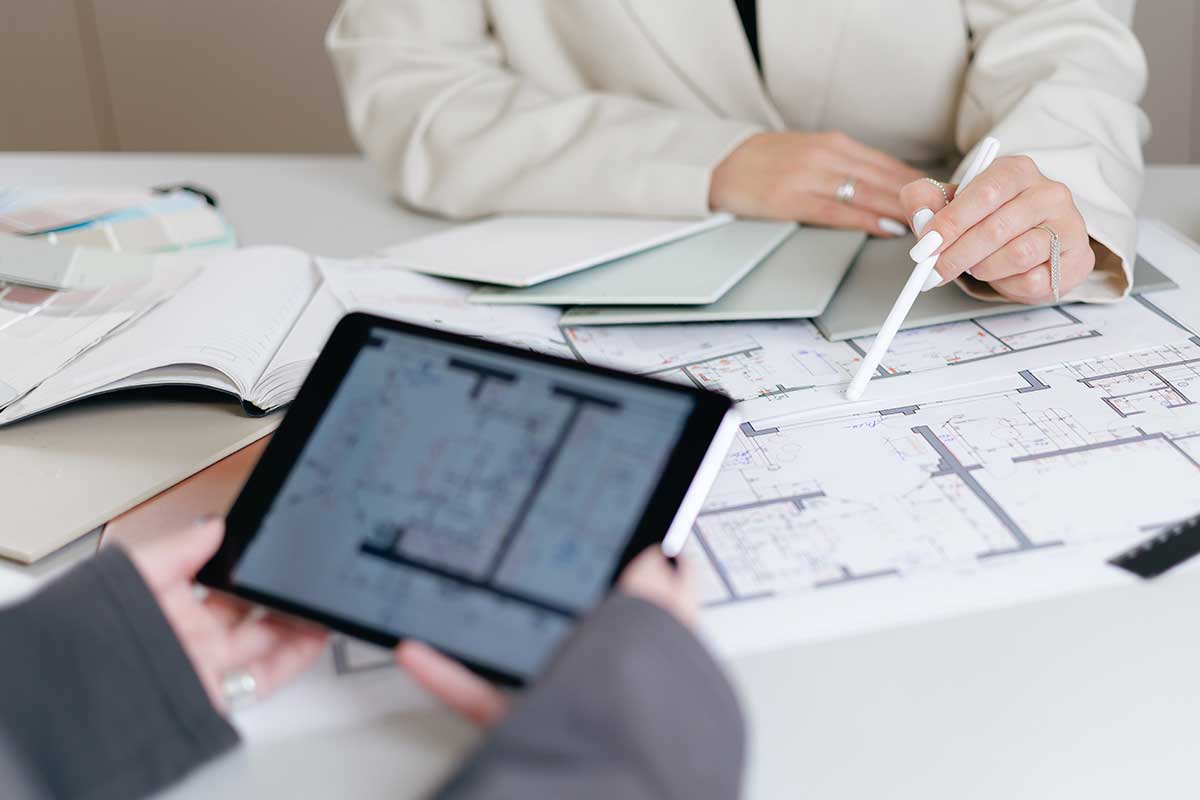 Two individuals examine blueprints together, focused on planning a construction project effectively.