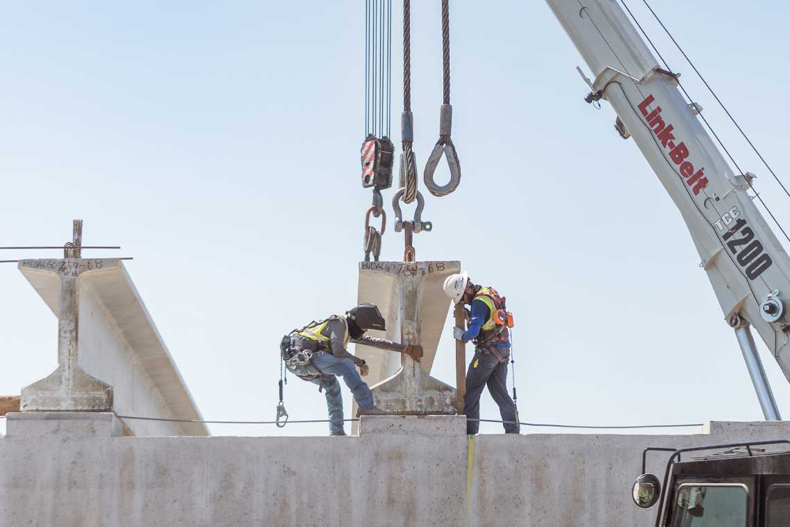 Two workers engaged in constructing a concrete structure